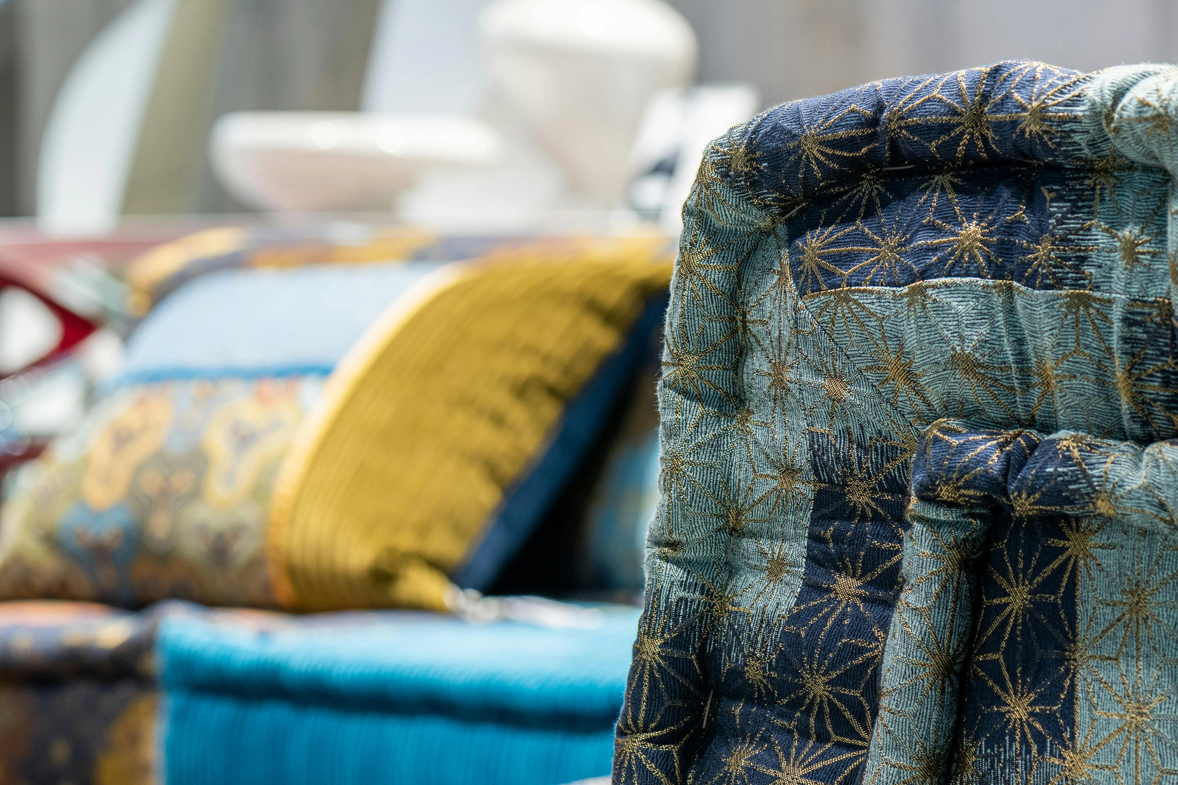 Colorful back of couch placed near bright sofas with vivid soft cushions in modern light furniture store on blurred background